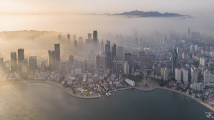 Fototapeta premium Aerial View of Coastal City Skyline Enveloped in Morning Mist