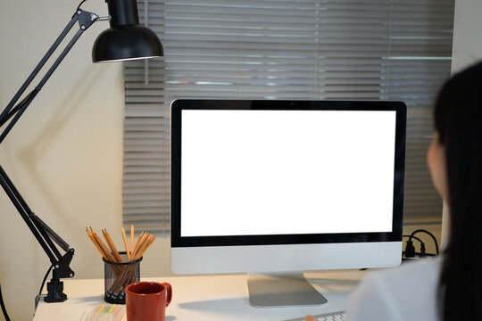 Rear view of businesswoman working with computer in modern office