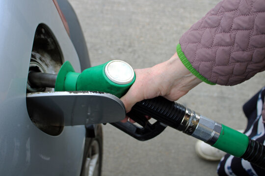 Close-Up of Hand Holding Fuel Pump Nozzle Refueling Car at Petrol Station &ndash; Gasoline, Energy and Transportation Concept