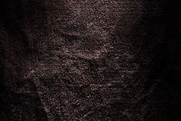 Fototapeta premium Macro shot of deep brown plush terry fabric showing detailed pile loops and dramatic lighting with moody shadows for an elegant background. 