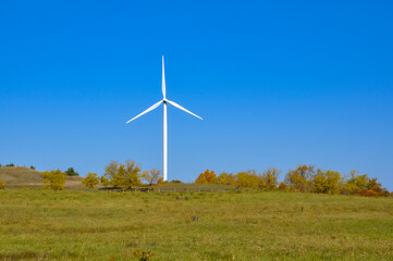 Fototapeta premium Wind turbine in the field in a sunny day