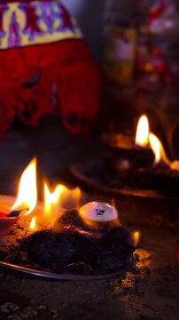 Close-up of a traditional small havan (holy fire) and a glowing clay diya at home during Navratri, featuring a bright flame and smoke in a dark, spiritual setting.
