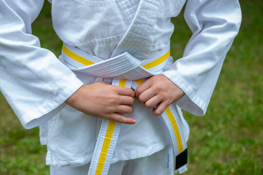 white-yellow belt, child athlete in judo uniform, dedication and strength in martial arts, martial arts training, physical fitness