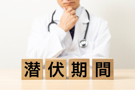 「潜伏期間」と書かれたブロックと悩む医師