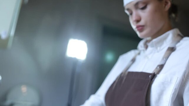 A female chef cooks in the kitchen at home wearing a chef's costume