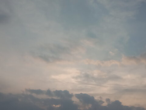 Natural texture of gray clouds in a hazy sky. Low-angle shot of the atmosphere during a cloudy sunset.