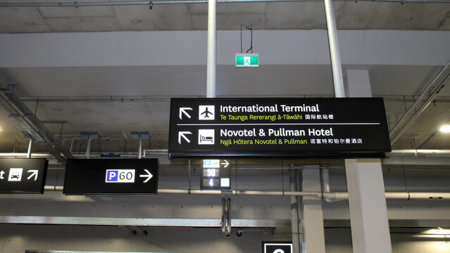 Auckland, New Zealand - March 12, 2026: Airport signs providing directions for travelers written in English, Māori, and Chinese. Editorial Use Only.