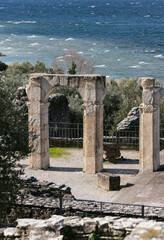 Fototapeta premium Ancient stone arch ruins near Lake Garda with turquoise water, Italy