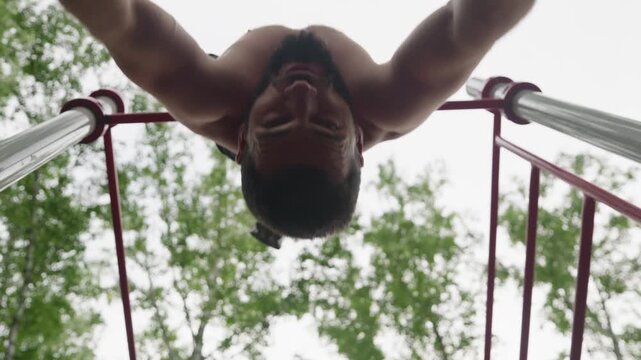 Black athlete performing pullups outdoors on park bars, lowangle under trees, shirtless muscular man executing calisthenics routine, focused grip and controlled motion, urban fitness