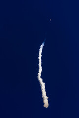 Fototapeta premium Rocket with satellites launch with smoke trail against deep blue sky