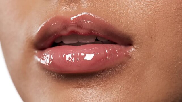 Close up of a female licking lips with pink gloss