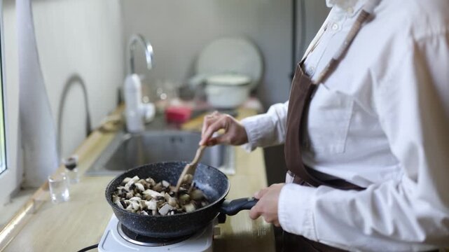 A female chef cooks in the kitchen during the day