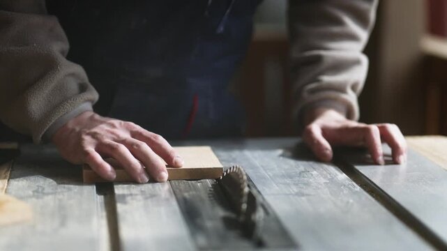 A skilled woodworker carefully places a piece of wood on a table saw, preparing for a precise cut. The craftsman ensures proper positioning before starting the woodworking task in the workshop.