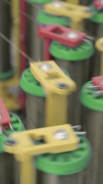 Braiding equipment, machine for weaving ropes, cables or wires is working, bobbins are moving. Close-up handheld shot, real time speed.