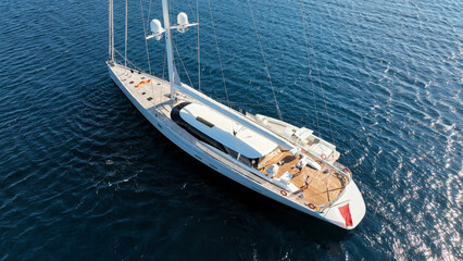 Aerial drone photo of beautiful luxury sail boat with wooden deck anchored in deep blue Mediterranean sea  © aerial-drone