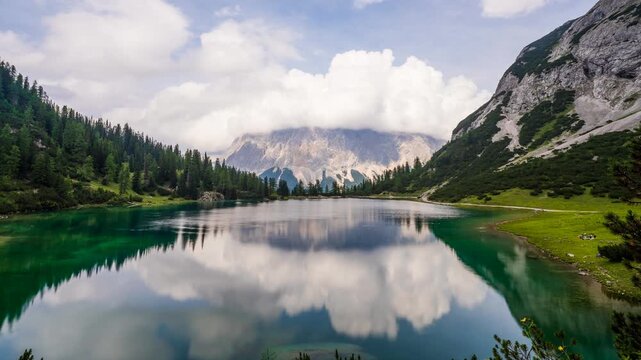 Seebensee Lake Timelapse with Zugspitze Mountain Reflection; Scenic Austrian Alps Landscape in Tyrol featuring Turquoise Water Moving Clouds and Alpine Peaks at Summer Establishing Shot