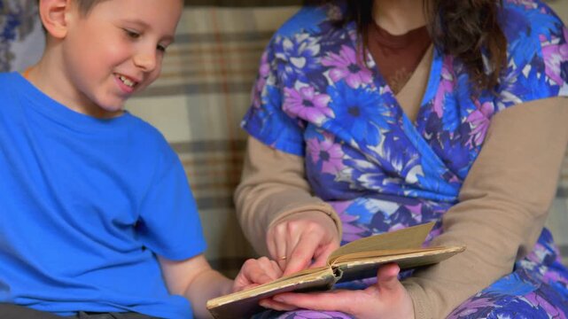 Smiling Boy and Mother Reading Old Vintage Book Together at Home &mdash; Family Bonding, Early Literacy, Childhood Curiosity and Intergenerational Storytelling