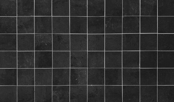 Black square ceramic tile wall background with white grout lines, modern dark bathroom or kitchen interior stone texture pattern, minimalist architecture backdrop for design and copy space.