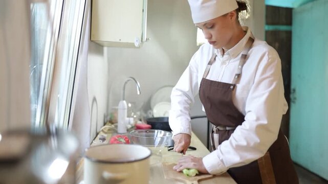 young female cook cooking in the kitchen at home