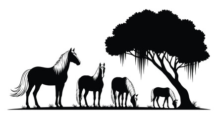 Horses grazing beneath a large tree in a striking silhouette © RKGolam