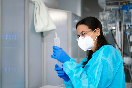 Medical professional preparing syringe for treatment in hospital