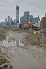 Obraz premium Muddy York: view of heavy machinery at development of Biidaasige Park (west of Cherry St) with view of Toronto skyline