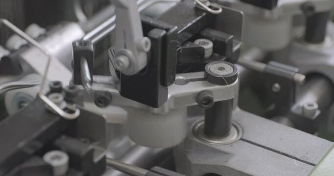 Spinning equipment, weaving machine, the jacquard loom is working. The parts of the mechanism move rhythmically, performing reciprocating movements. Close-up handheld shot, real time speed.
