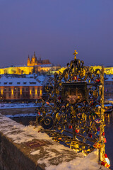 Fototapeta premium Touching holy relief on Karluv most, Prague with castle view
