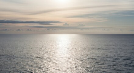 Obraz premium Serene Ocean Sunset Scene with Reflective Water and Calm Atmosphere