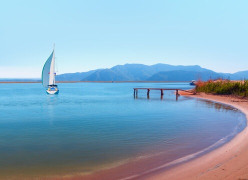 Lone white yacht sailing with Panoramic view of Iztuzu beach  - Dalyan, Turkey