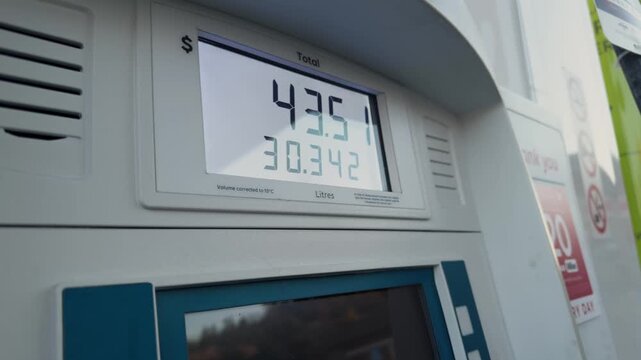 Close-up view of fuel pump display showing high gasoline prices at self-service petrol station in Canada. Driver filling up car tank, rising fuel costs and energy crisis concept during daytime