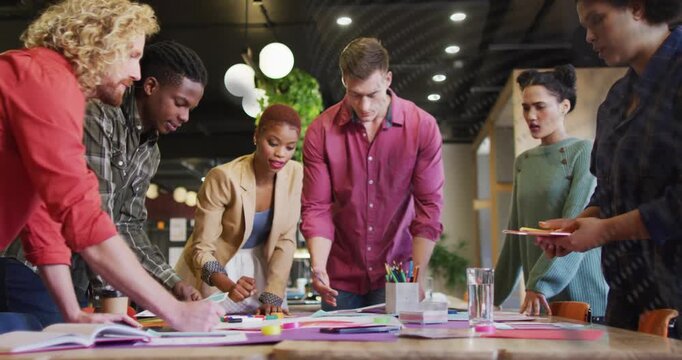 Vertical video: Starting planning session, six colleagues arranging papers at office, beige blazer