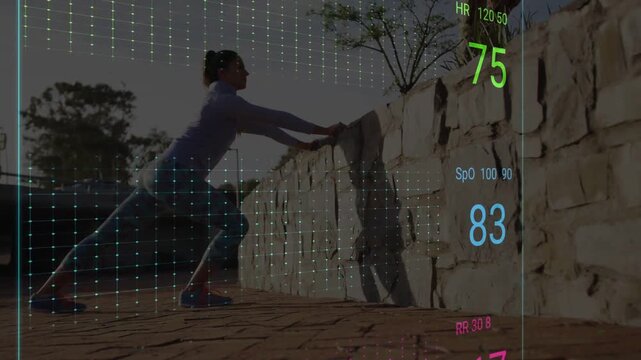 Vertical video: Reacting to HUD appearing, woman in top and leggings lunging by stone wall at plaza