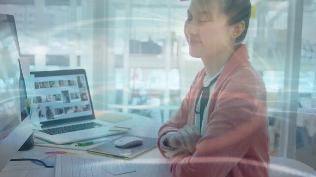 Vertical video: Reacting to laptop at desk, woman in cardigan turning to camera smiling, copy space
