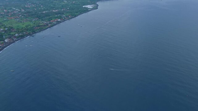Aerial view of boat cruising along amed coast in bali, indonesia