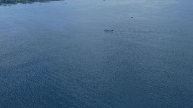 Traditional balinese jukung boat sailing near amed with mount agung volcano