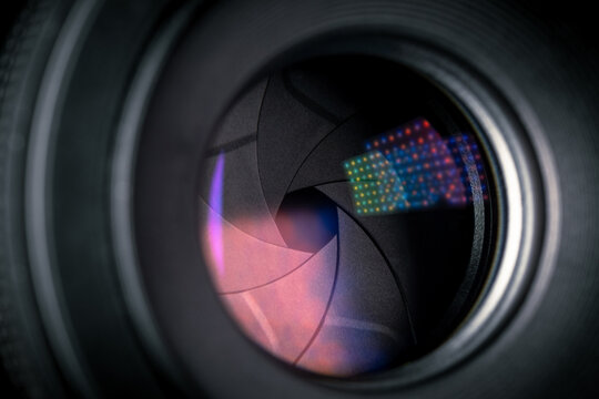 Black lens with aperture blades and bright light reflections on the glass