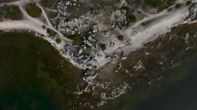 Top down drone shot descending over limestone sea stacks and rocky coastline at Folhammar raukf&auml;lt, Gotland, Sweden along the Baltic Sea