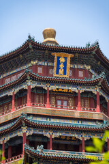 Fototapeta premium The majestic multi-tiered Tower of Buddhist Incense, showcasing its intricate colorful eaves and traditional architecture against a clear blue sky at the Summer Palace in Beijing, China - 27 May 2025