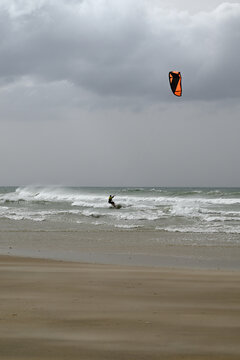 Kitesurfer at Conil de la Frontera beach. Wild autumn weather with big waves at Conil de la Frontera, Andalusia, Spain, Europe.