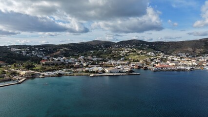 Fototapeta premium Aerial View of a Scenic Greek Island Harbor with Moored Boats and Hills
