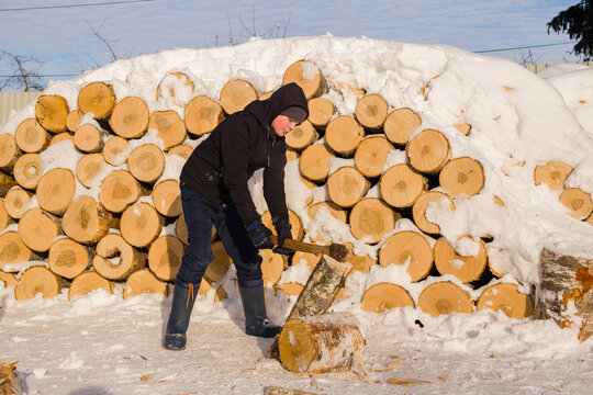 A teenage boy learns to chop wood