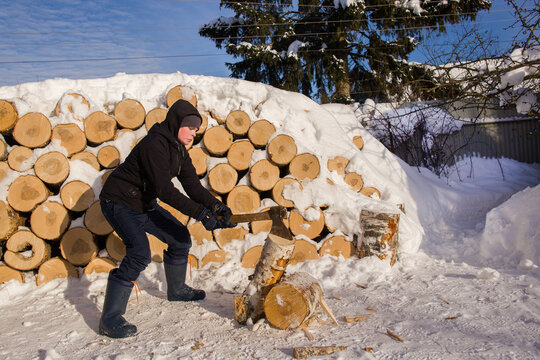 A teenage boy learns to chop wood