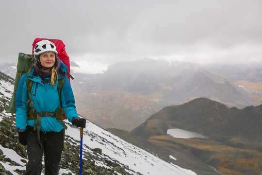 Young woman climber against the backdrop of beautiful mountains.