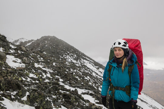 Young woman climber against the backdrop of beautiful mountains.