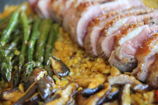 Paella with magret de pato and green asparagus