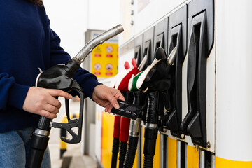 Hand holding bank card near gasoline nozzle during car refueling. © Rabizo Anatolii