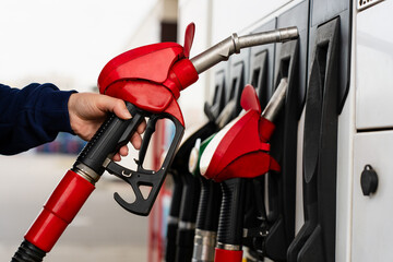 Hand holding fuel dispenser nozzle during car refueling. © Rabizo Anatolii