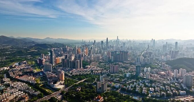 Panoramic aerial view of modern skyscrapers and urban skyline in Shenzhen, China, showcasing rapid city development, financial district architecture, and mountain backdrop.
