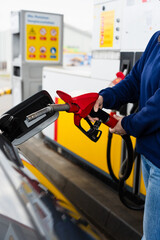 Hand holding fuel pump while refilling car at gas station. © Rabizo Anatolii
